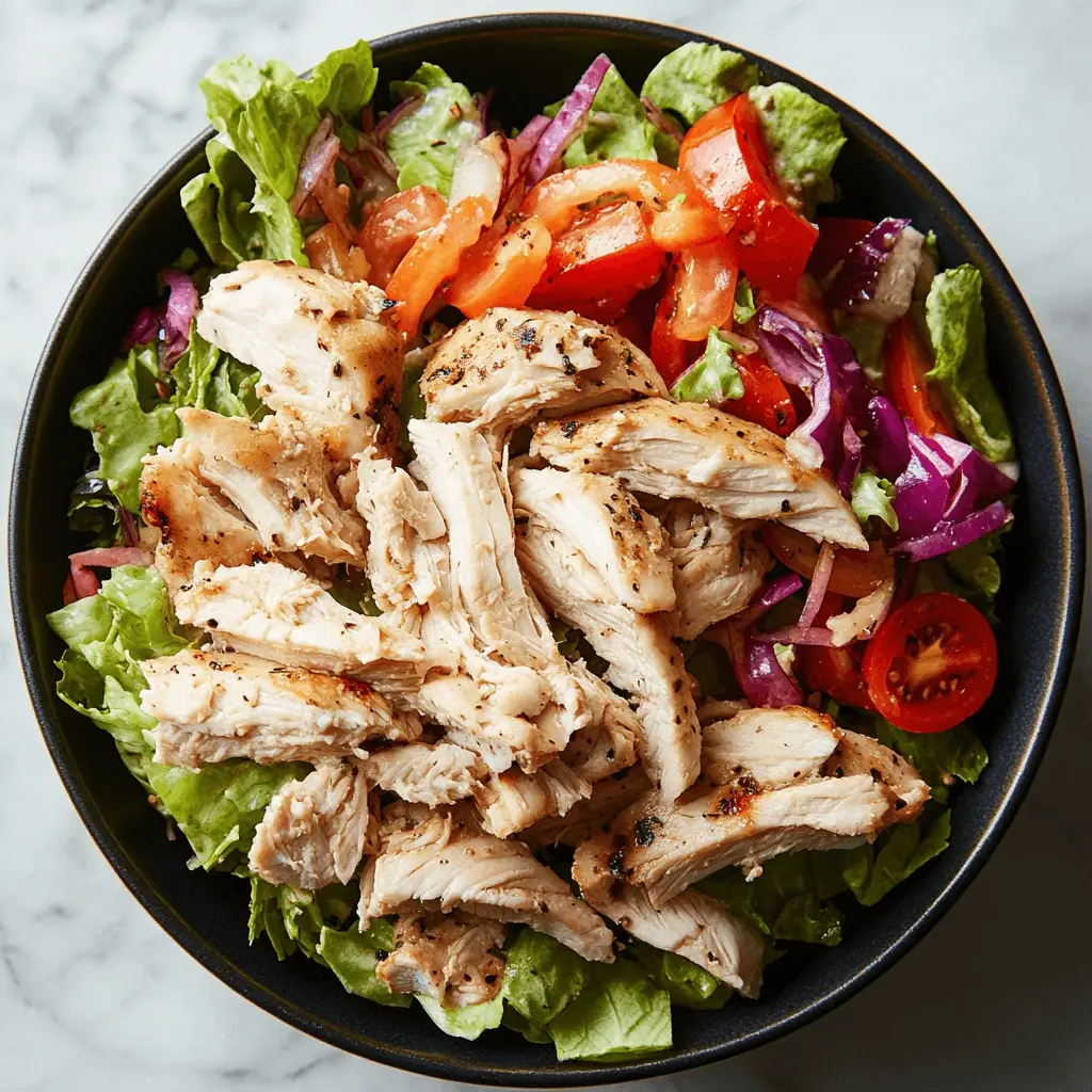 Grilled chicken served over fresh vegetables in a healthy chicken salad bowl.